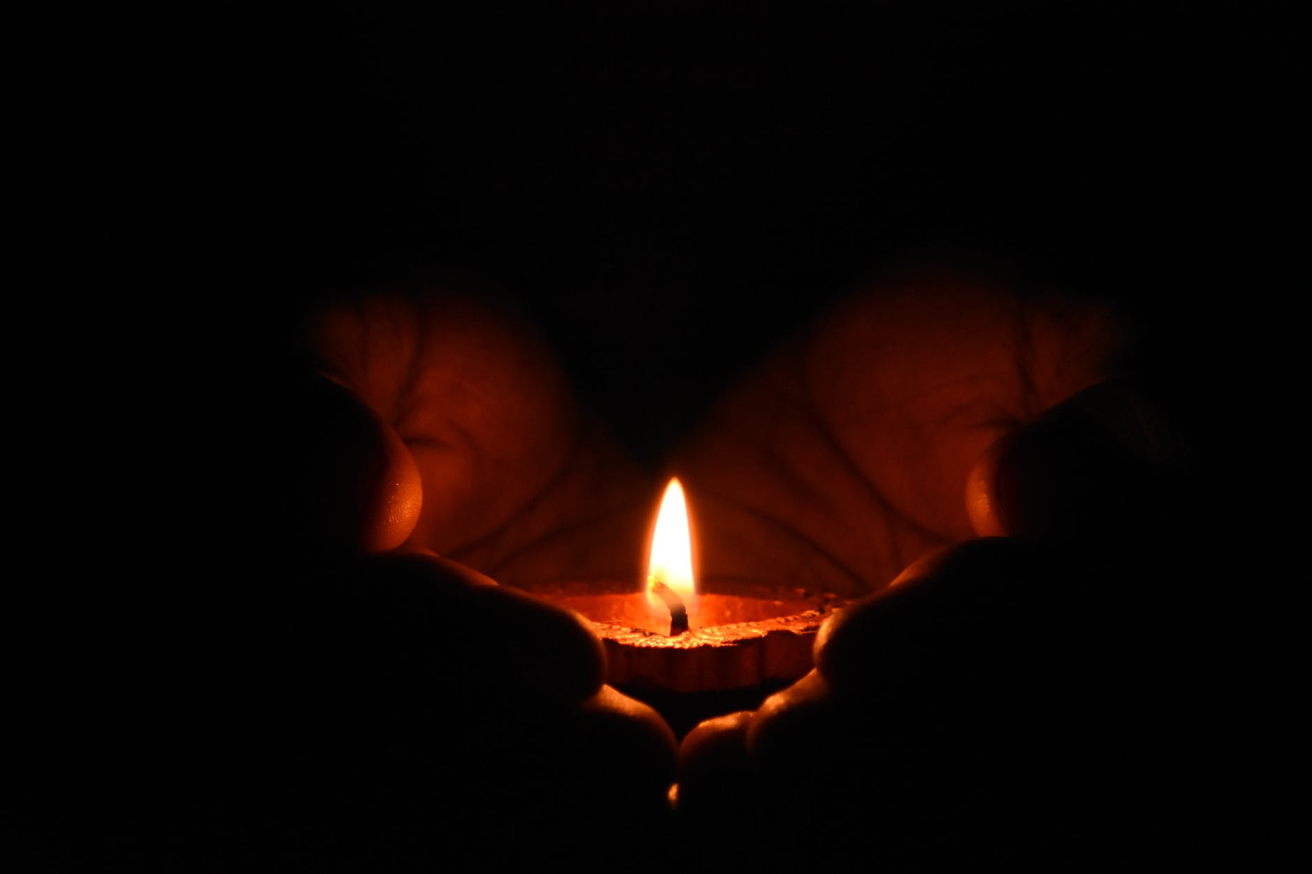 tealight candle on human palms